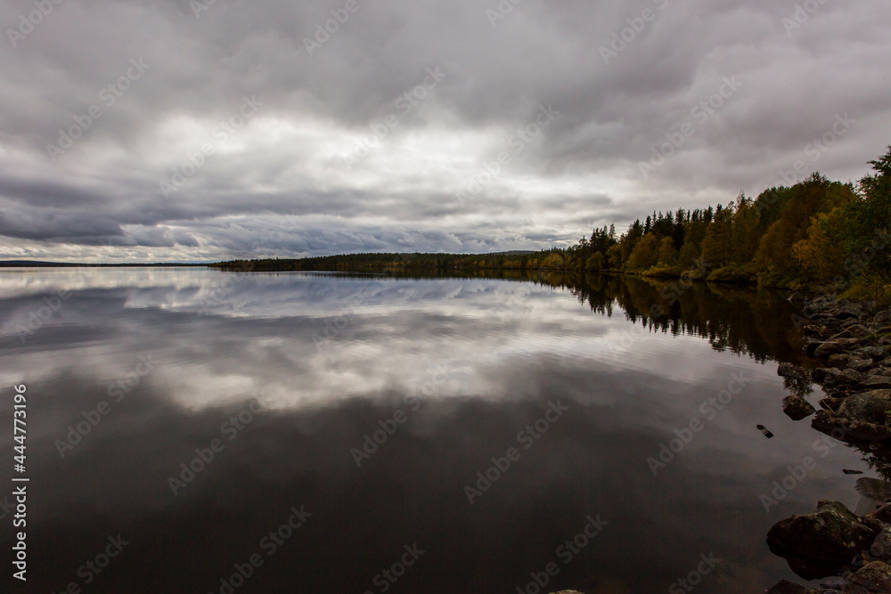 Dramatic autumn clouds reflection in Muonio lake, Lapland, Northern Finland