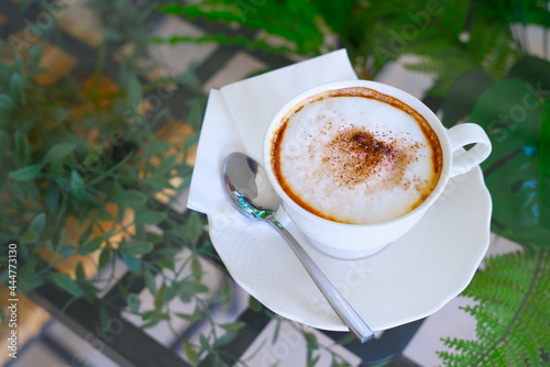 Fotografie Coffee powder sprinkled on whipped cream of hot americano drinks in a white cup