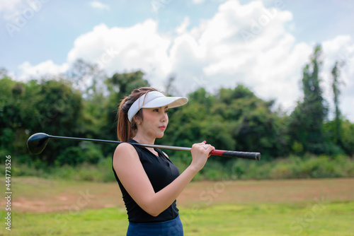 Portrait of golfer asian woman holding golf wood at the country club,Happy woman concept © reewungjunerr