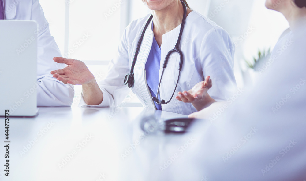 Serious medical team discussing patient's case in a bright office Serious medical team discussing patient's case in a bright office