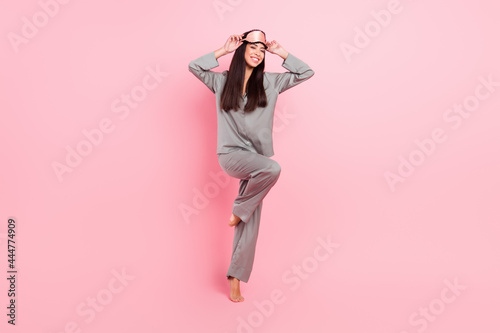 Full length photo of charming sweet lady sleepwear mask dancing smiling isolated pink color background