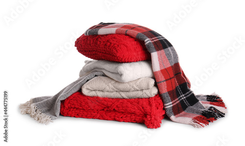 Stack of folded warm plaids with pillow on white background