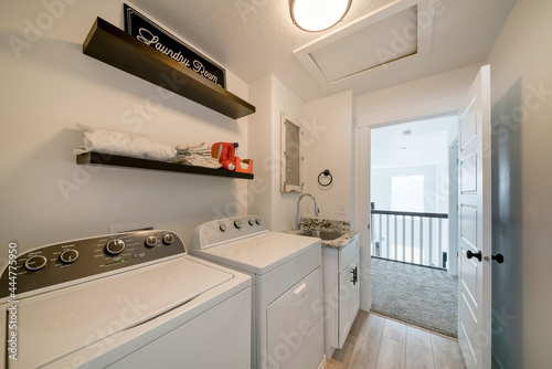 Laundry room interior with laundry machines and vanity sink