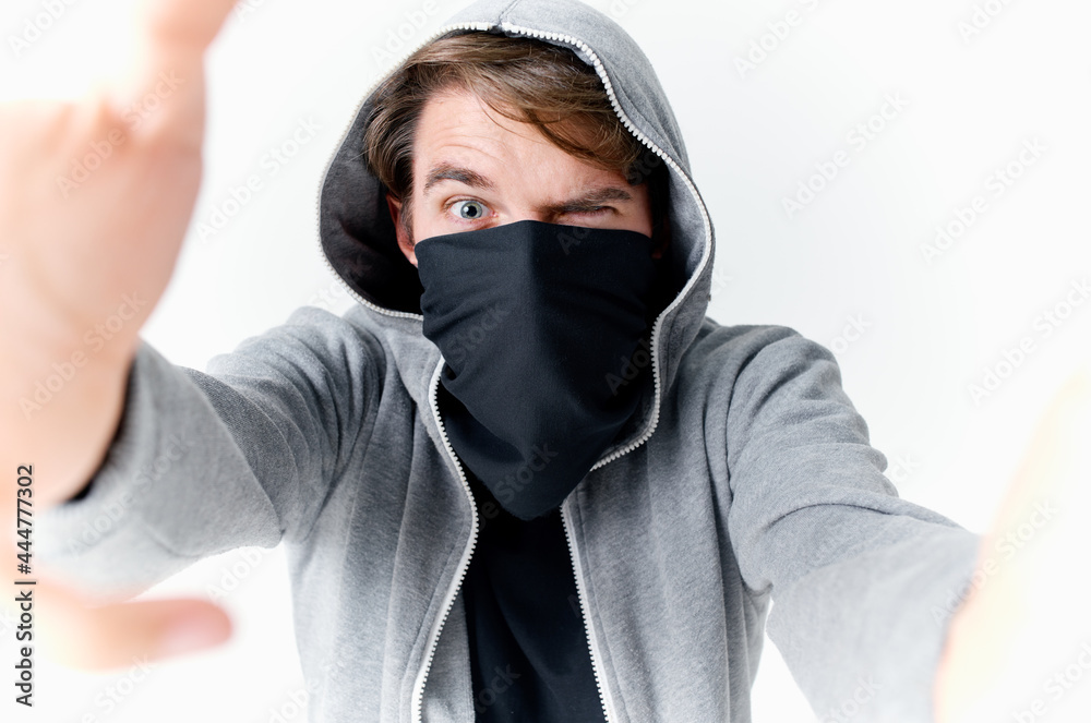 a man in a hood hides his face in a mask bully anonymity a man in a hood hides his face in a mask bully anonymity