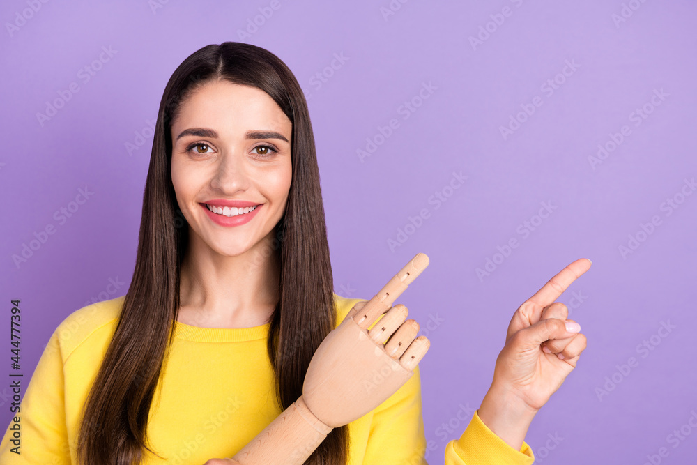 Photo of cheerful young happy woman point finger empty space sale wooden hand isolated on violet color background Photo of cheerful young happy woman point finger empty space sale wooden hand isolated on violet color background