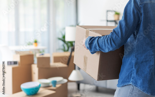 Woman carrying boxes in her new home