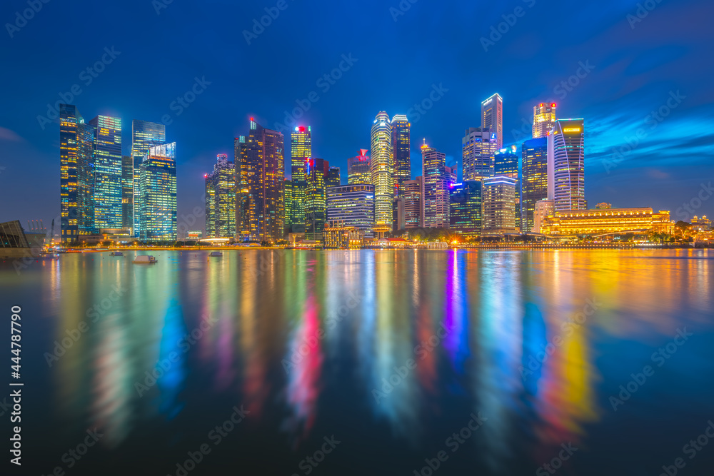 Fototapeta premium A modern urban landscape or economy in Singapore's business district with skyline and lights from the city center buildings and nightlife at Marina Bay, Singapore.