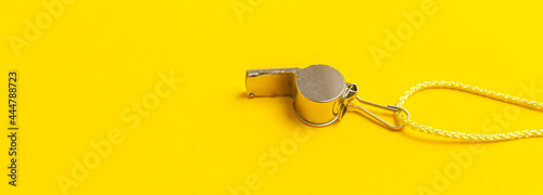 Sports whistle on yellow background. Concept - sport competition, referee, statistics, challenge. Basketball, handball, futsal, volleyball, soccer, baseball, football and hockey referee whistle photo