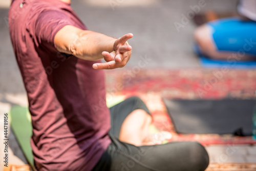 People exercising yoga class outdoors 