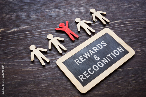 Plate with Rewards and recognition words and wooden employee figures. photo