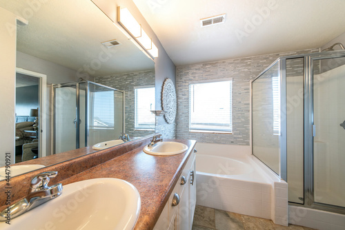 Master bathroom with a warm lightning and stone tile walls