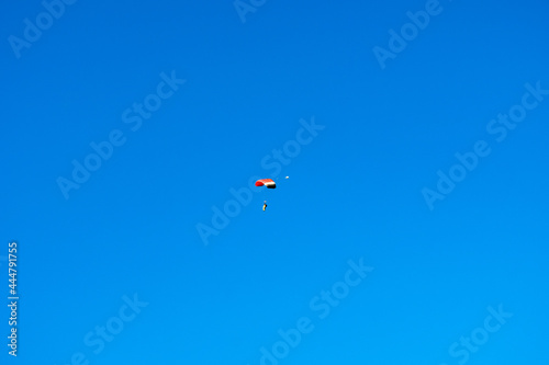 Personas cayendo planeando desde el cielo azul con el parqacaidas abierto 