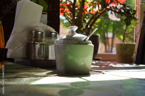 Breakfast by window at sunny morning. Sugar bowl on table. photo