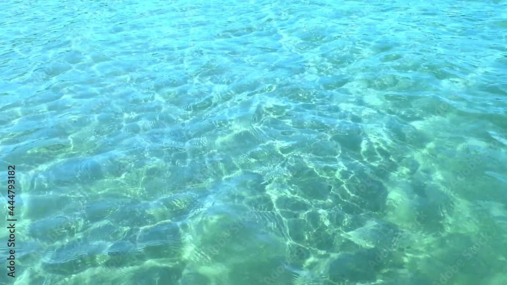 Waves of clear sea water that let in sunlight. The southern warm water of the ocean coast with the glare of the sun.
