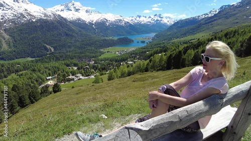 Woman relax on top of Piz Nair in Switzerland. Swiss cable car St. Moritz Bad-Signal in Corviglia location of Piz Nair mountain of Albula alps. Lake St. Moritz and Silvaplana skyline in Grisons Canton photo