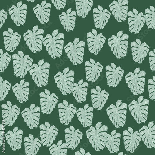 Modern tropical leaves philodendron plant silhouette backdrop. Exotic wallpaper. Chaotic monstera leaf seamless pattern on green background. V © smth.design