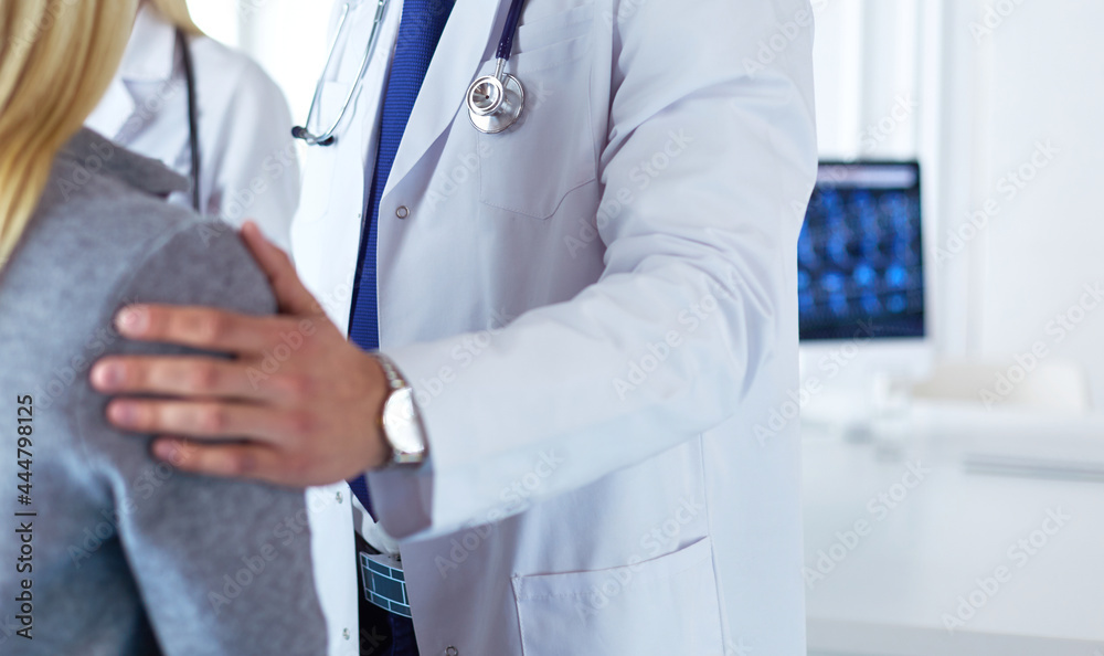 Handsome male doctor consulting a couple about infertility in his medical office