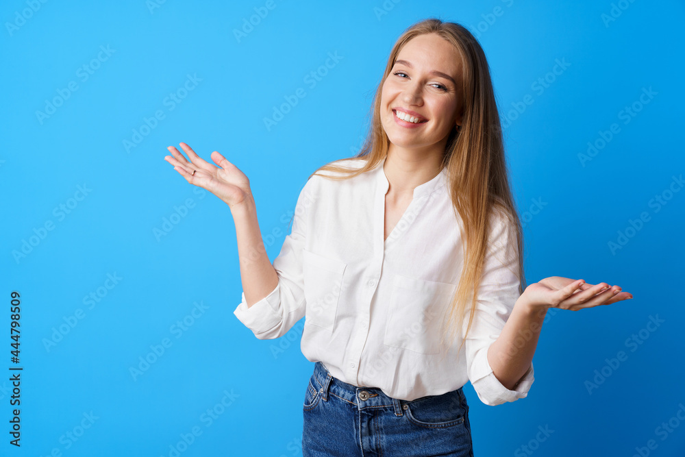 Surprised young blonde woman throwing up her hands against beige background Surprised young blonde woman throwing up her hands against beige background