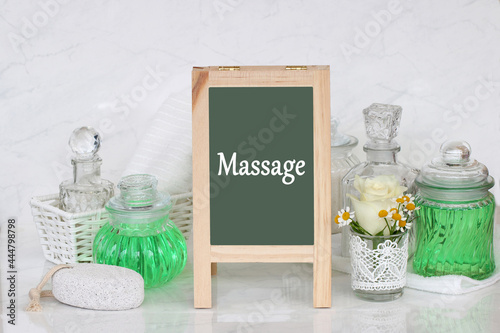 Tafel mit dem Text Massage und verschiedene Wellness Produkte.