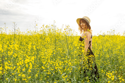 Redhead girl in a rapeseed field at sunset...