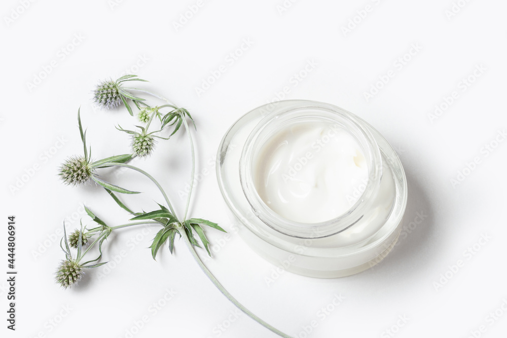 Moisturizing face cream in a glass jar on a white background. Purifying face mask with natural extracts and ingredients.