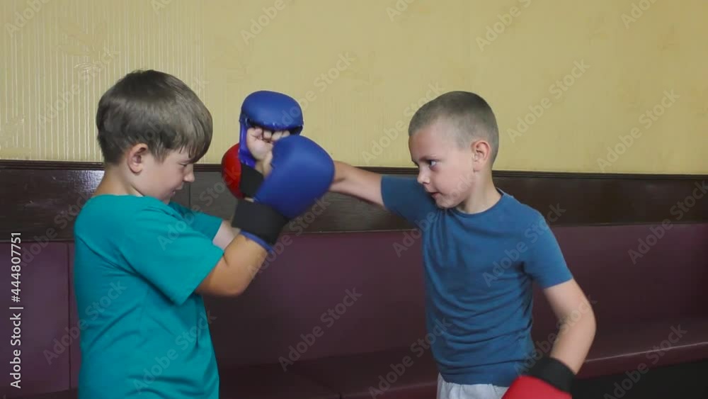 Athletes in T-shirts with pads on their arms practice punches and defense techniques Athletes in T-shirts with pads on their arms practice punches and defense techniques