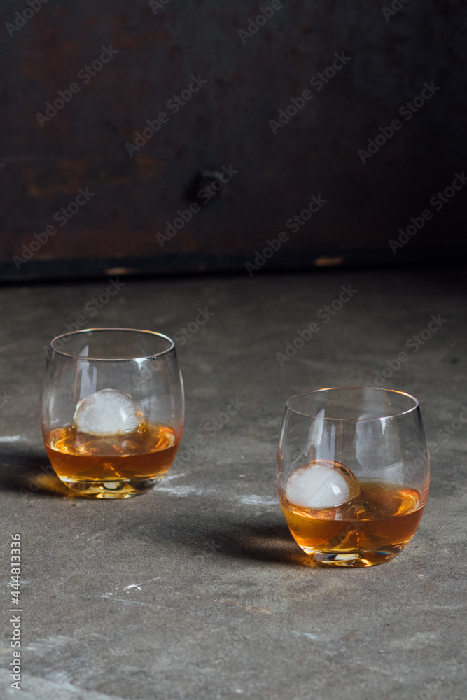 two drams of whiskey in a glass with sphere spherical ice two drams of whiskey in a glass with sphere spherical ice