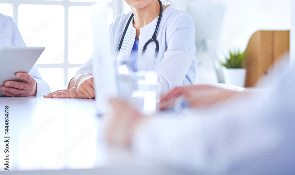 Doctors consulting with each other in a hospital conference room Doctors consulting with each other in a hospital conference room