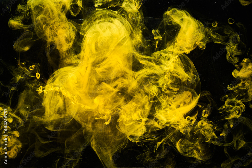 Fototapeta premium Abstract liquid art, yellow smoke bomb on black background, amber color acrylic paints under water
