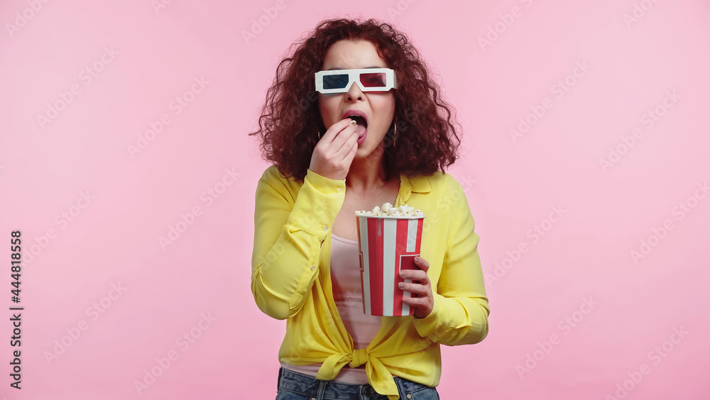 curly young woman in 3d glasses with open mouth eating popcorn isolated on pink curly young woman in 3d glasses with open mouth eating popcorn isolated on pink