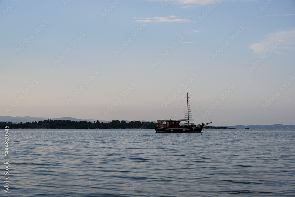 Photo of a boat sailing from the coast in the evening