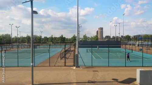 Courts in tennis centre, people playing tennis on fenced playground photo