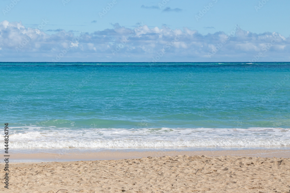 Calm blue waves breaking gently on Waimānalo Beach, Oahu, Hawaii, USA