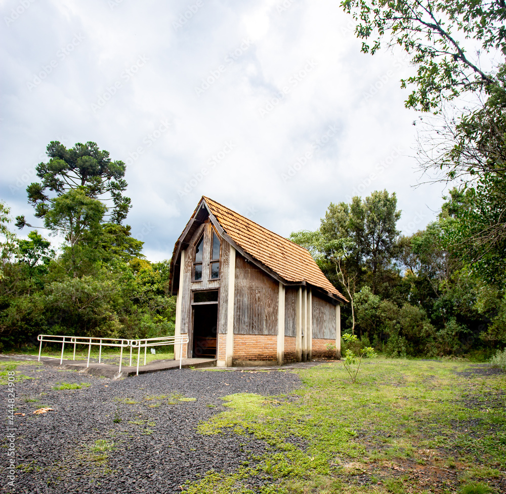 Prudentópolis, Paraná, Brazil, January,06,2018 - Catholic wooden chapel in the middle of the forest with a clean grass field around Prudentópolis, Paraná, Brazil, January,06,2018 - Catholic wooden chapel in the middle of the forest with a clean grass field around
