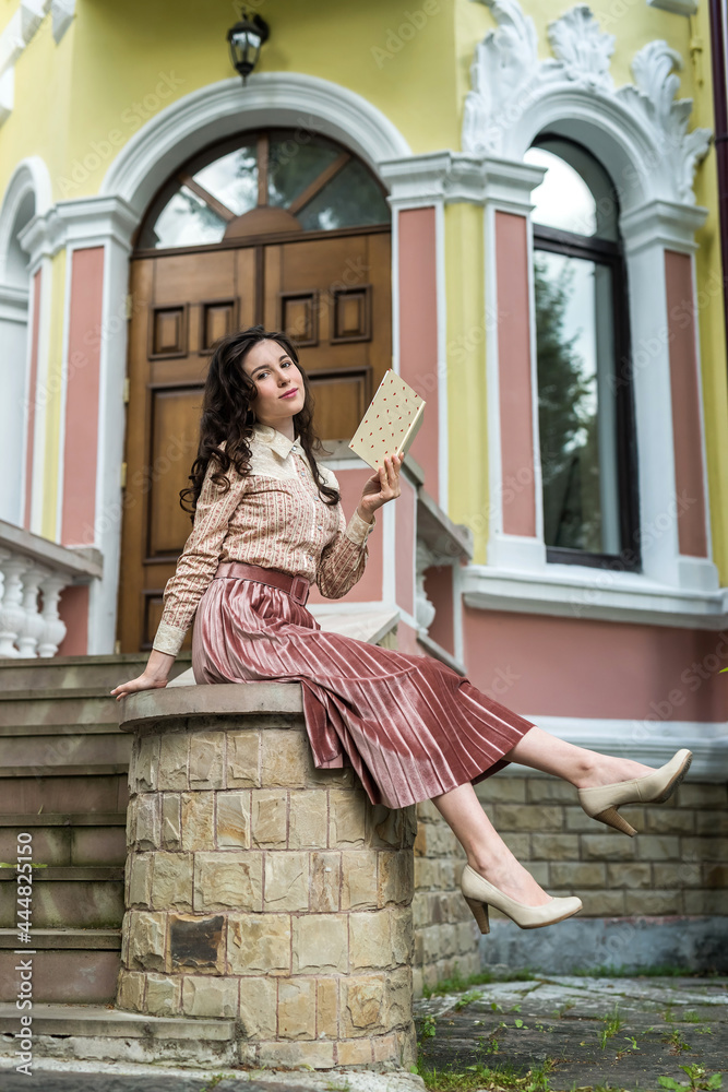 happy beautiful young ukrainian woman posing near a city house