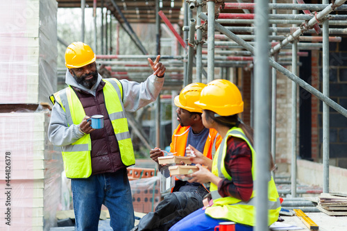 Construction workers enjoying lunch break at construction site photo