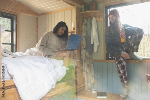 Couple relaxing with laptop and coffee in cabin rental photo