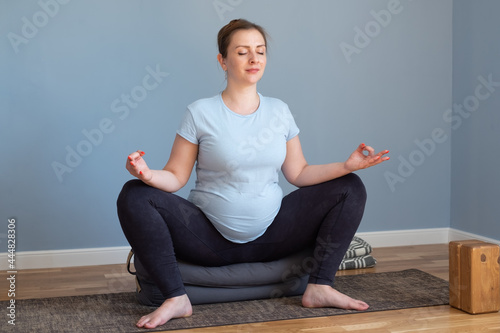 Pregnant yoga woman enjoying yoga practice at home. photo