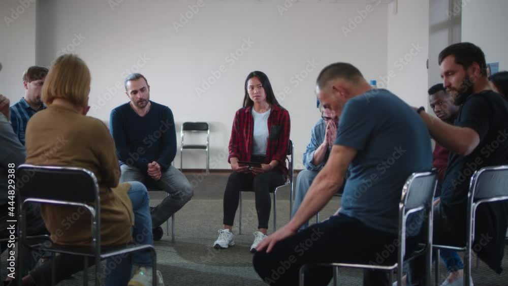People supporting upset man during group meeting People supporting upset man during group meeting