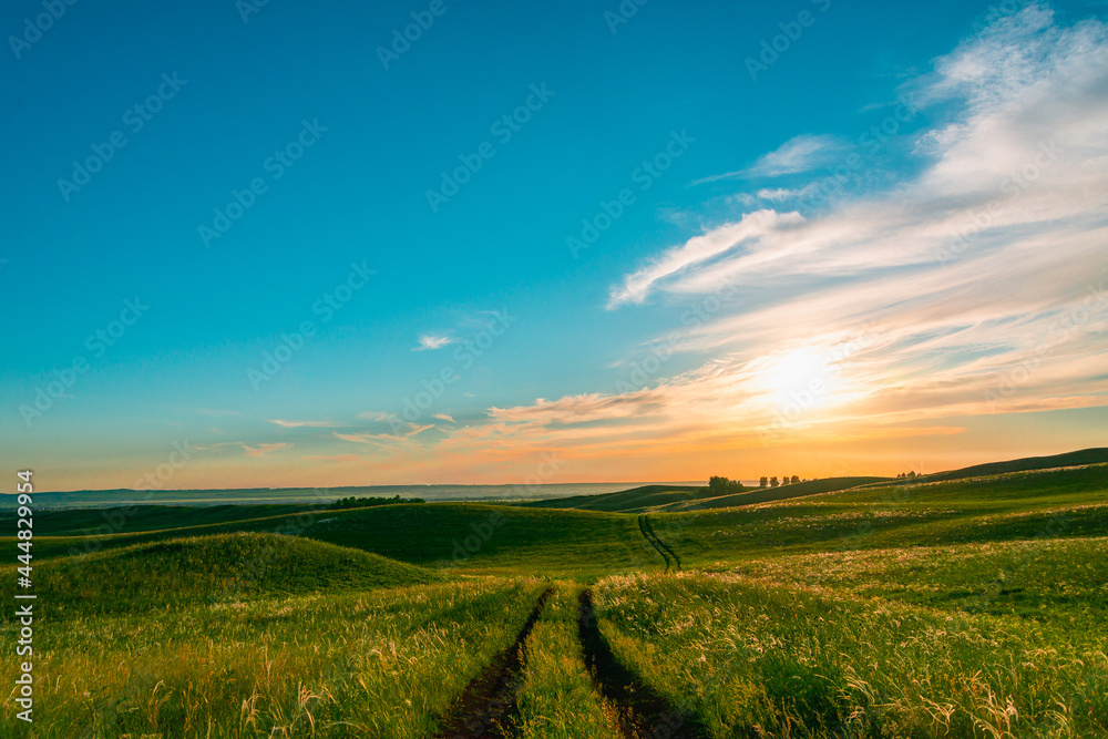 Obraz premium Sunset and road along the hills.