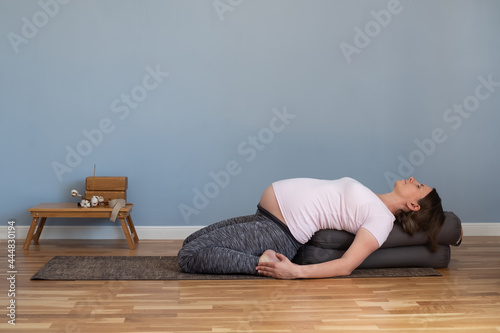 Pregnant woman practicing yoga in suptha virasana exercise
