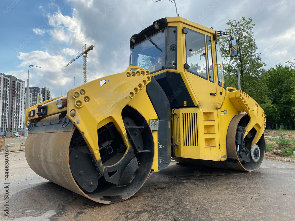 Yellow powerful large new modern road roller for asphalt paving and road repair at construction site. Construction machinery