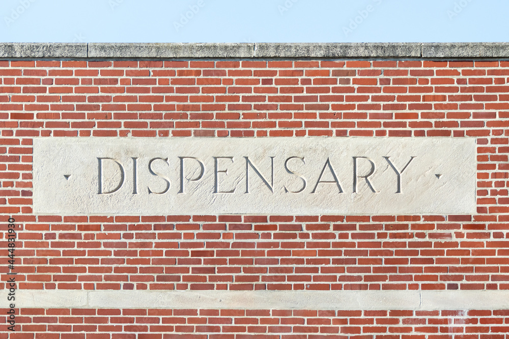 Stone dispensary sign on a brick building—marijuana and cannabis Stone dispensary sign on a brick building—marijuana and cannabis