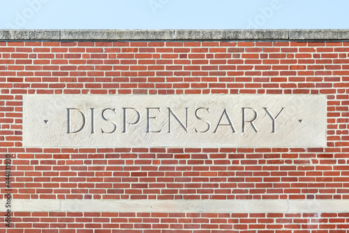 Stone dispensary sign on a brick building—marijuana and cannabis