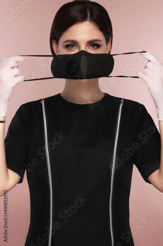 Manicurist in working form in black mask. Nail photo content photo