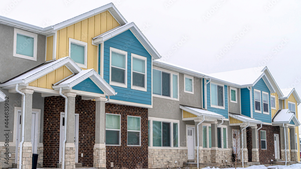 Pano Two storey houses with colorful walls in a neighborhood landscape with snow