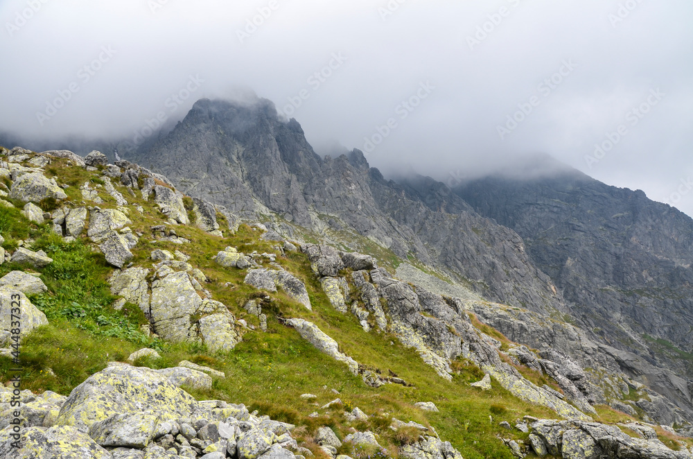 Fototapeta premium Scenic view Of landscape and rocky foggy mountains against cloudy sky in High Tatras, Slovakia