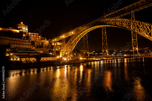 Night shot of Porto looking towards Vila Nova de Gaia, with the illuminated "Ponte Dom Luís I" bridge, the Serra do Pilar monastery, and the old port wine cellars along the Douro River, Portugal