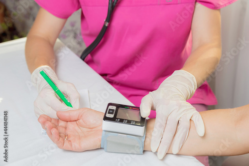 A girl doctor measures the blood pressure of an adult woman. The patient asked for help with high blood pressure. Health and medicine concept.