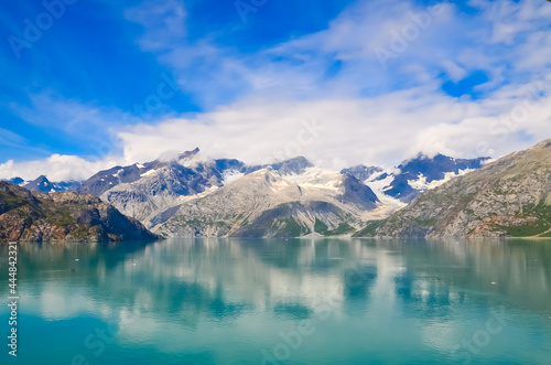 Alaska landscape mountains and water, sunny day, blue sky with clouds. Mountains reflection in the water. Remote location, unplugged. Wild beauty in nature. Untouched environment
